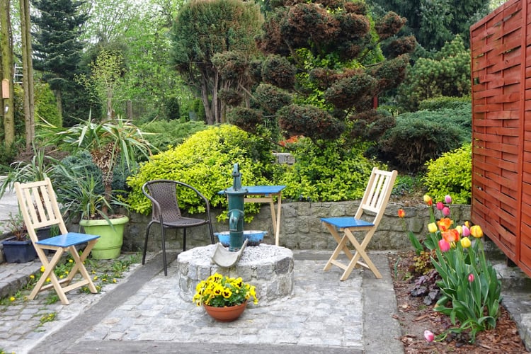 petit jardin -coin-repos-chaises-table-pliantes-arbustes