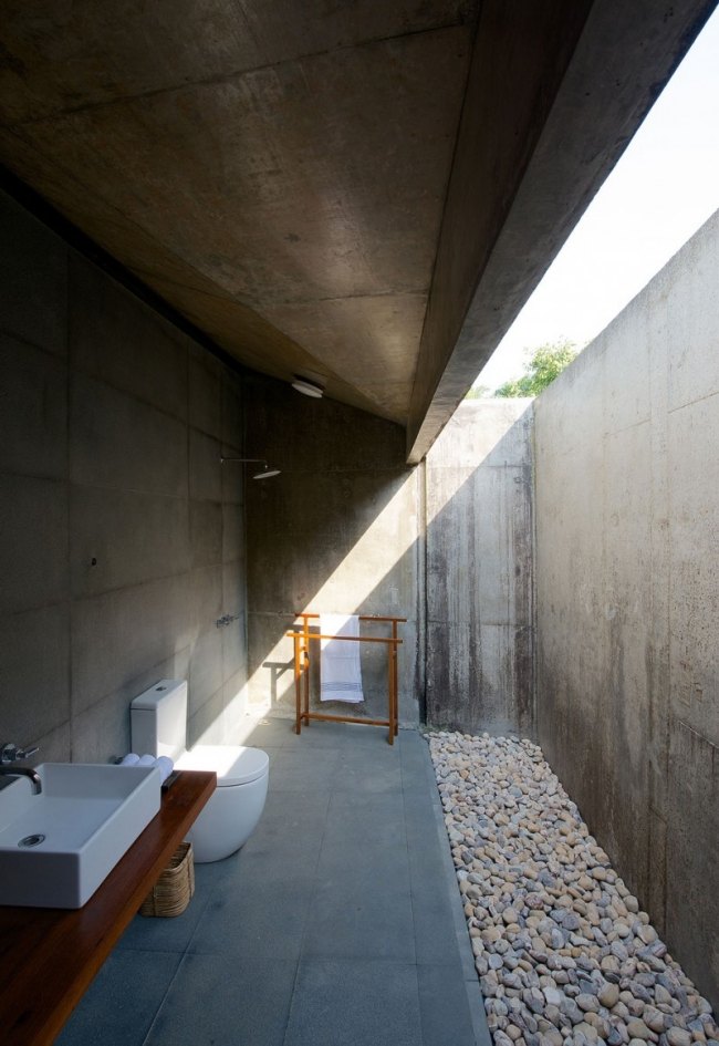 salle-bain-ouverte-murs-béton-lumière-naturelle-galets
