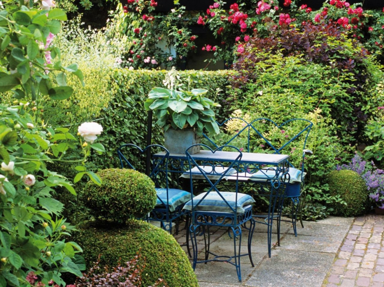 terrasse-jardin-meubles-métal-bleus-coussins-plantes-vertes-rosiers