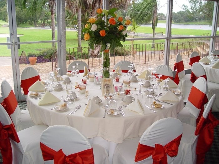 centre-table-mariage-hauteur-housses-chaises-blanches-noeuds-rouges
