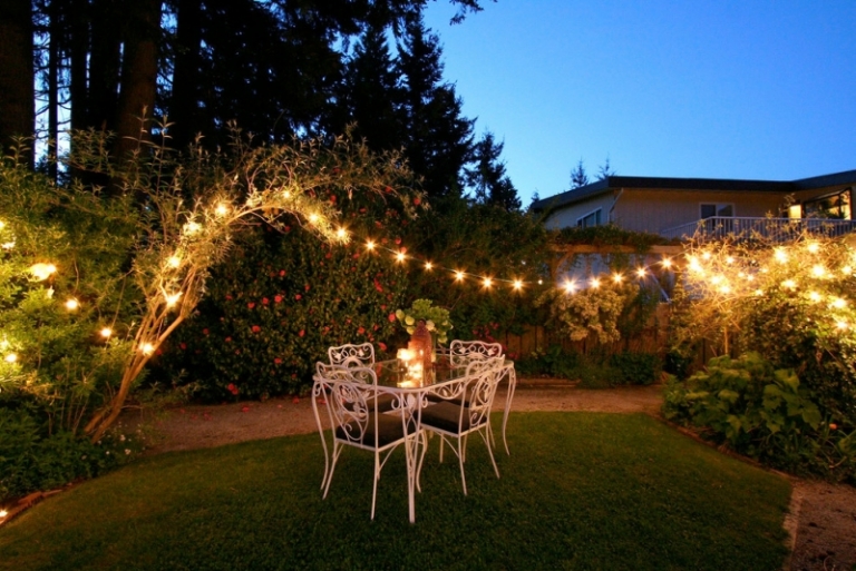 eclairage-jardin-guirlandes-lumineuses-coin-repas-fer-forge-pelouse