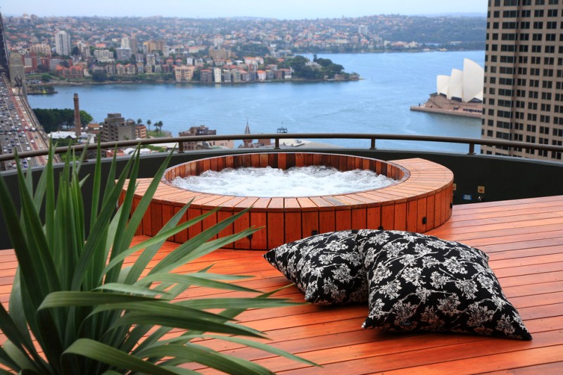jacuzzi-extérieur-ronde-terrasse-bois-composite-coussins-décoratifs-noir-blanc