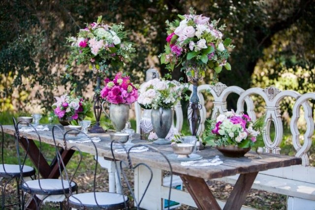 idees-decoration-mariage-romantique-extérieur-fleurs-roes-tbale-bois-chaises-fer