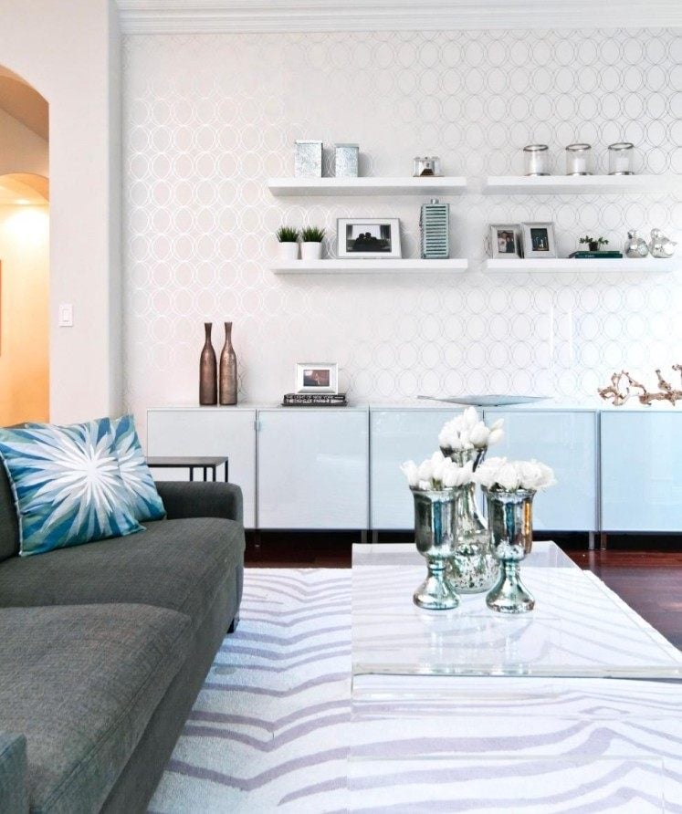 meuble-salon-blanc-canapé-gris-foncé-tapis-blanc-étagères-papier-peint