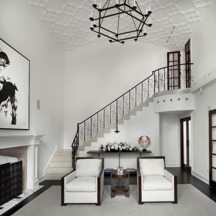 meuble-salon-blanc-escalier-lustre-fauteuils-blancs-cheminée mobilier de salon