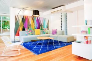 amenagement-petite-chambre-colorée-tapis-bleu-déco-murale-canapé-rembourré-coussins