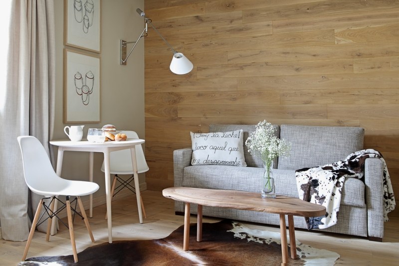 amenagement-petite-chambre-lambris-mural-canapé-rembourré-gris-chaises-table-blanches-tapis
