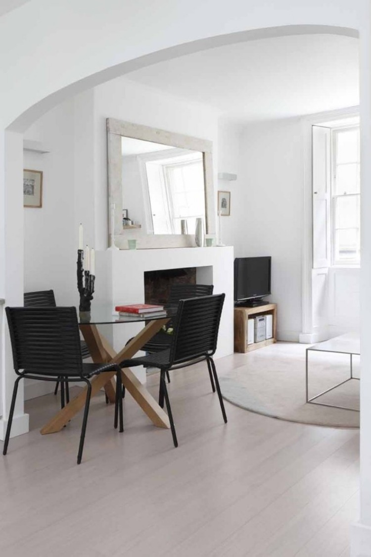 cheminée-ouverte-classique-miroir-table-ronde-verre-chaises-noires