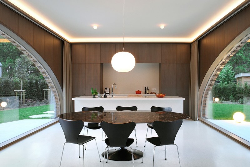 design-conception-cuisine-armoires-bois-îlot-blanc-table-ovale-marbre-chaises-noires