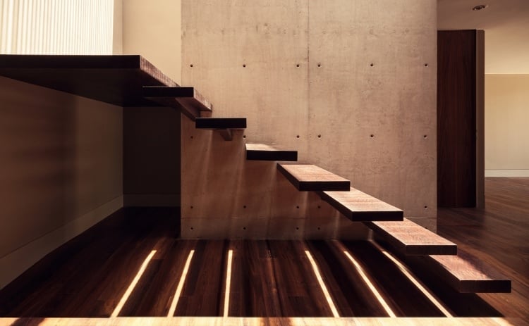 escalier-suspendu-marches-bois-massif-mur-béton-brut