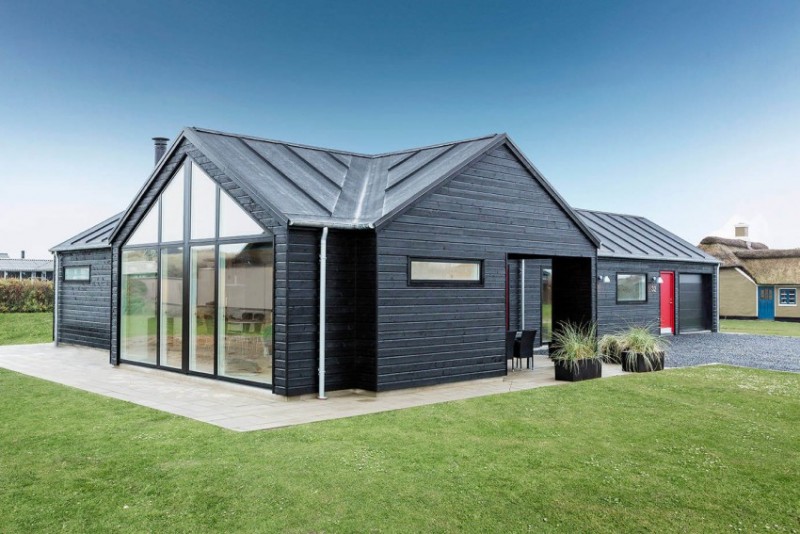 interieur-bois-moderne-extérieur-revêtement-bois-noir-terrasse-carrelée-gazon