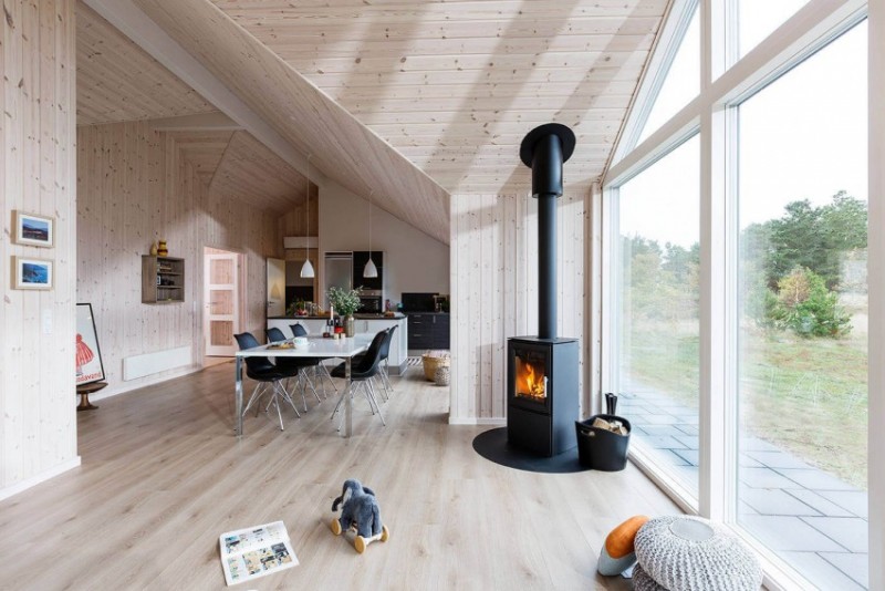 interieur-bois-moderne-plan-ouvert-cheminée-noire-table-blanche-chaises-noires intérieur bois