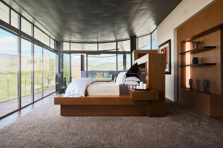 interieur-maison-luxe-chambre-coucher-lit-bois-tête-lit-rangement-fenêtres-étagères