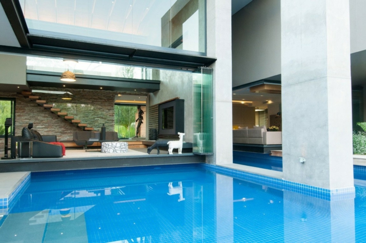 interieur-materiaux-naturels-piscine-fenêtres-coulissantes-salon-canapé-cuir-cheminée