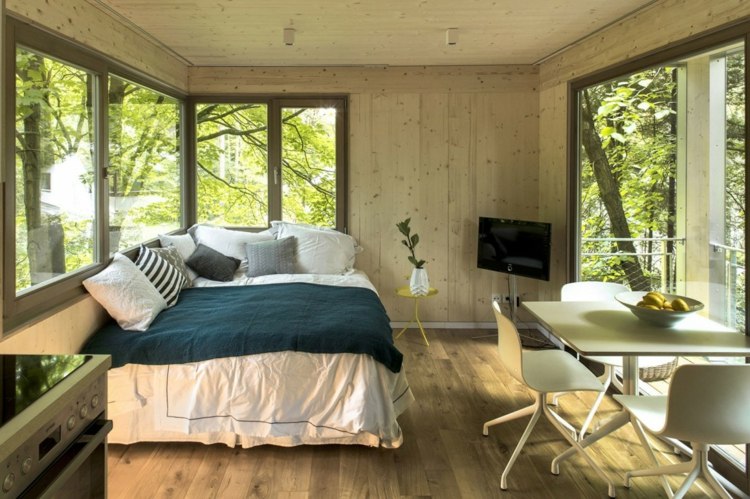 intérieur-confortable-cabane-dans-arbres-revêtue-bois
