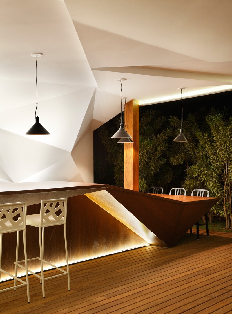 meuble-bar-design-forme-futuriste-suspensions-noires-chaises-blanches-jardin
