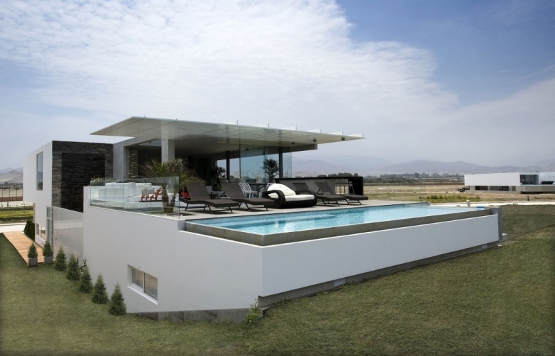 piscine-exterieur-hors-sol-terrasse-chaises-longues-noires-parois-verre-gazon