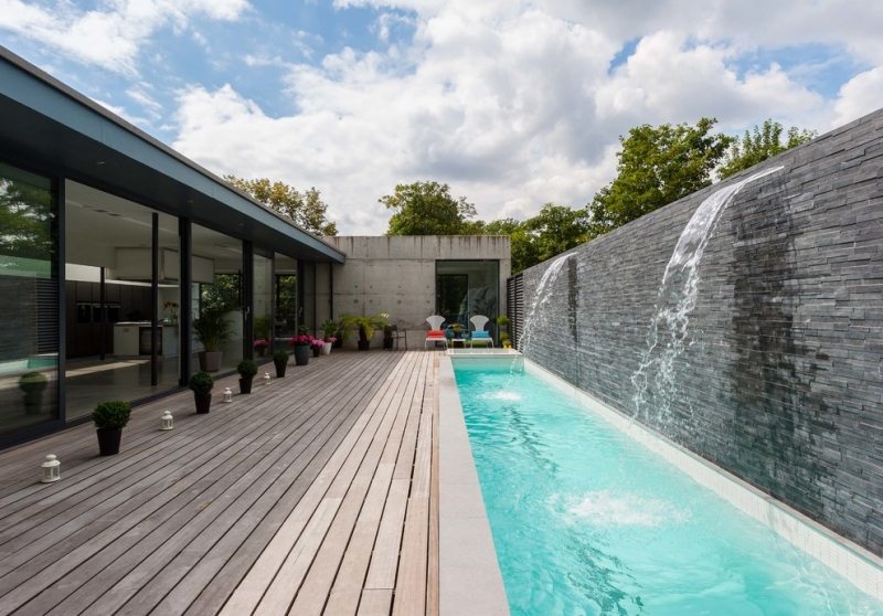 piscine-exterieur-rectangulaire-mur-pierre-cascades-plage-bois-composite