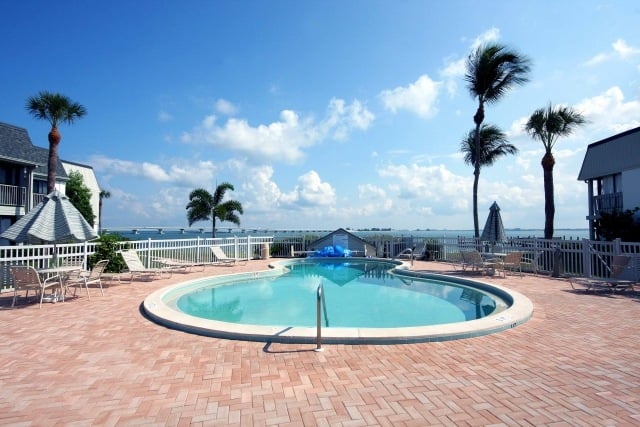 piscine-exterieur-revetement-sol-briques-coin-repas-palmiers