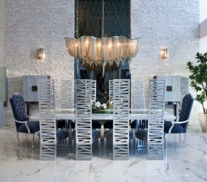 suspension-salle-manger-chaînettes-métaliques-sol-marbre-mur-pierre-chaises-dossiers-métalliques