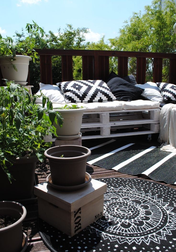 amenagement-balcon-banc-palettes-bois-tapis-noir-blanc-plantes-vertes-coussins aménagement balcon