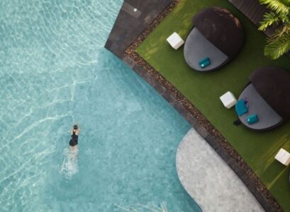 amenagement-paysager-palmier-piscine-encastres-chaise-longu-tabourets-blancs