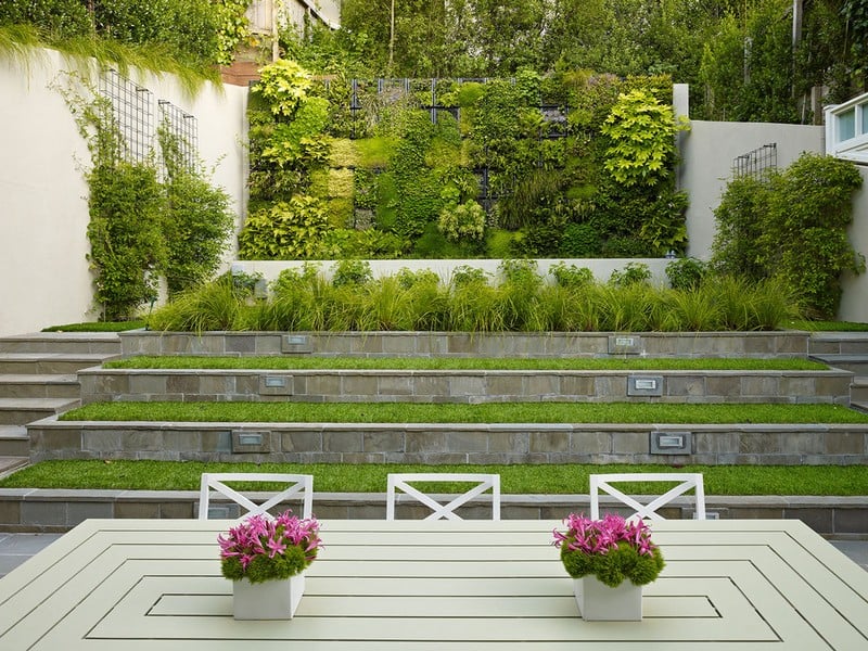 amenagement-petit-jardin-mur-végétalisé-graminées-ornement-table-chaises-bois