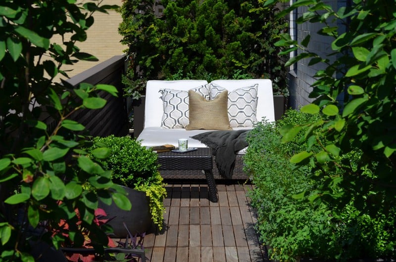 amenagement-petit-jardin-terrasse-bois-canapé-table-rotin-coussins-plantes-vertes