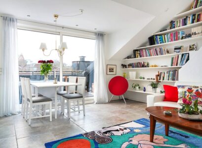 aménagement-de-combles-tapis-table-ovale-bois-canape-droit-coussin-etageres-murales