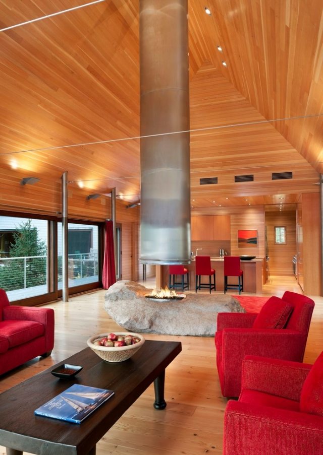 habillage-cheminée-moderne-ouverte-aspect-métal-fauteuils-rouges-table-basse-bois-plafond-bois