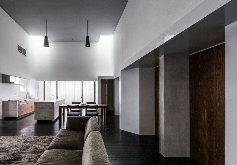 interieur-minimaliste-canapé-peluche-gris-suspensions-noires-îlot-marbre