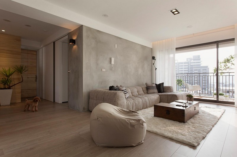 interieur-minimaliste-canapé-pouf-gris-clair-peinture-murale-aspect-béton-tapis-blanc-coffre-table-basse