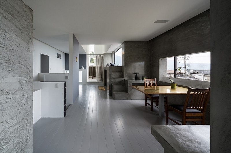 interieur-minimaliste-cuisine-coin-repas-murs-aspect-béton-table-chaises-bois