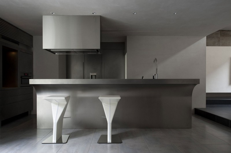 interieur-minimaliste-cuisine-îlot-gris-clair-futuriste-tabourets-bar-blancs