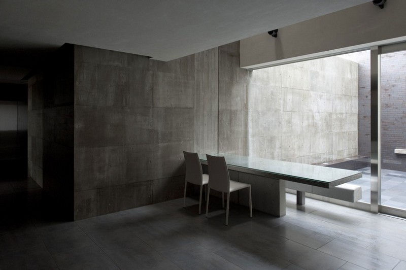 interieur-minimaliste-salle-manger-chaises-blanches-table-béton-murs-béton