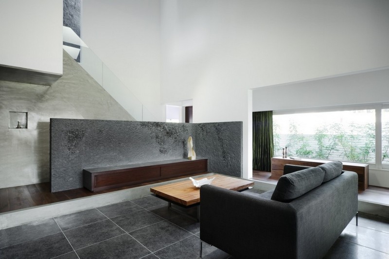 interieur-minimaliste-salon-commode-bois-sombre-parois-béton-canapé-gris-foncé intérieur minimaliste