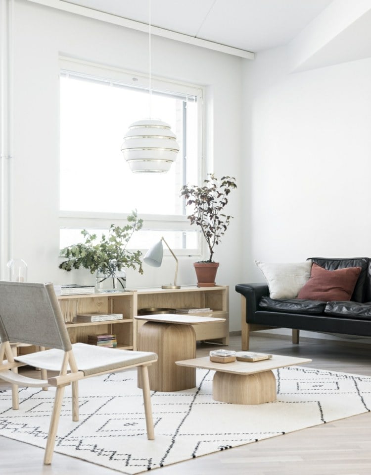 intérieur-scandinave-salon-canapé-cuir-noir-tapis-blanc-motifs-commode-table-basse-bois-clair intérieur scandinave