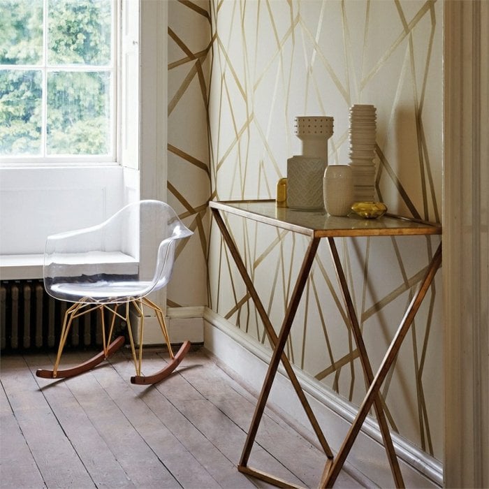 papier-peint-design-beige-clair-motifs-linéaires-or-table-appoint-métallique-chaise-eames-transparente papier peint design