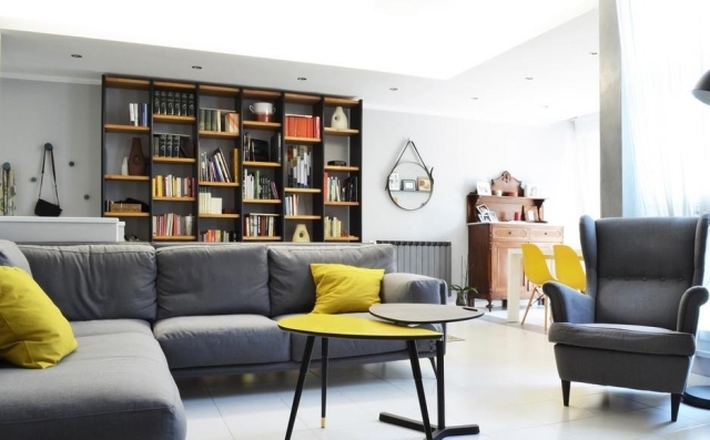salon-design-bibliothèque-canapé-fauteuil-gris-coussins-jaunes-table-basse-jaune-gris