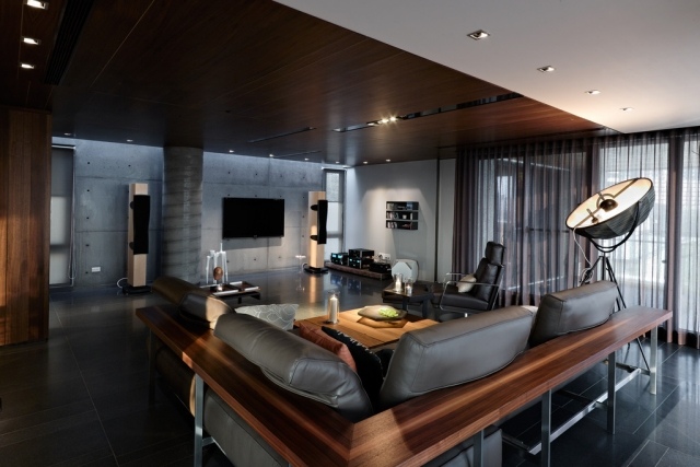 salon-design-canapé-bois-sièges-cuir-gris-murs-béton-plafond-bois-spots-led