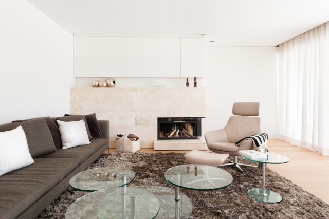 salon-design-canapé-gris-fauteuil-relax-beige-cheminée-meuble-rangement-blanc