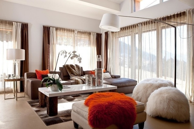 salon-design-rideaux-transparents-table-basse-marbre-bois-canapé-marron-couvertures-fausse-fourrure