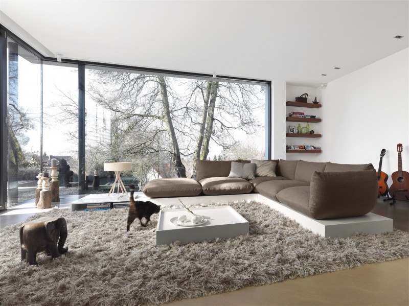 salon-design-tapis-shaggy-canapé-moderne-marron-table-basse-blanche-fenêtres-panoramiques