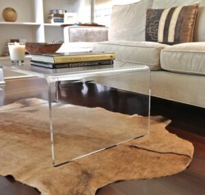 table-basse-acrylique-plexiglas-tapis-vache-canape-rembouree-bougie-deco-interieure
