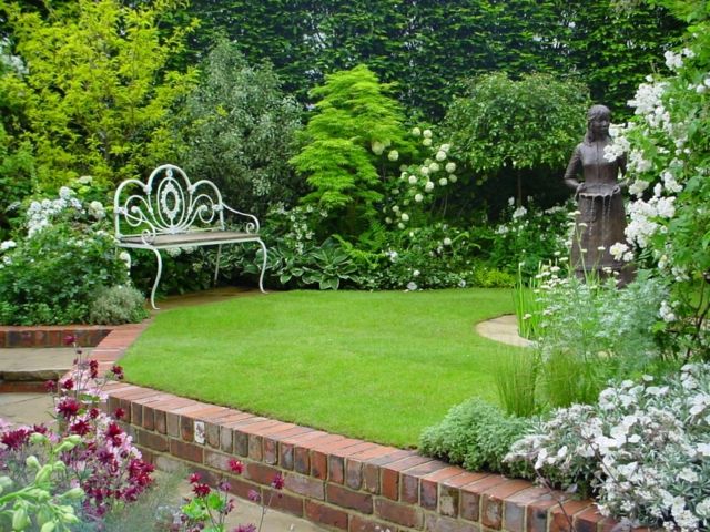 amenagement-jardin-pelouse-verte-banc-jardin-métal-bois-rosiers-fleurs aménagement de jardin