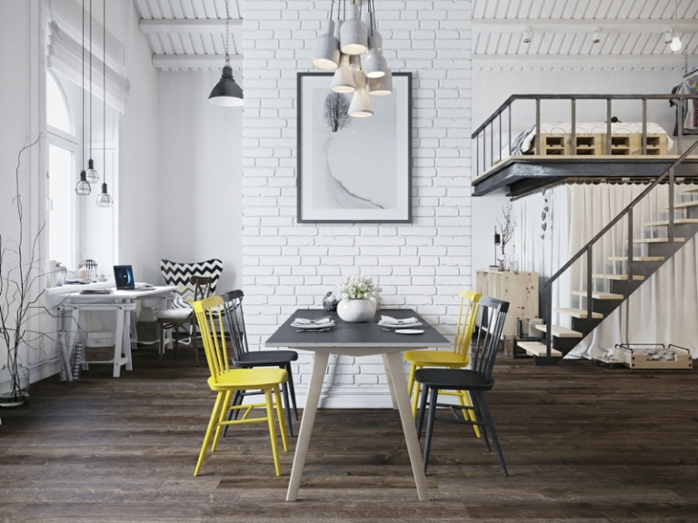 amenagement-studio-style-scandinave-chaises-jaune-noir-table-noir-blanc-mur-brique-blanche-tableau-suspensions