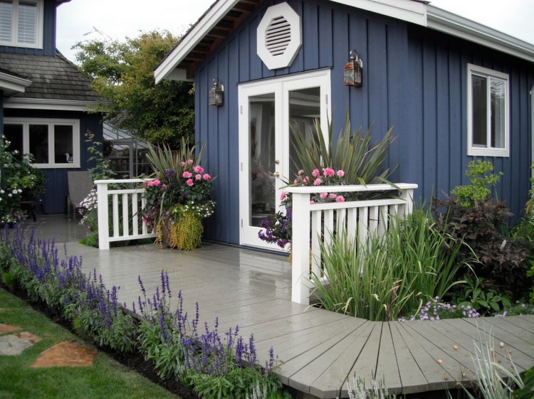 cabane-jardin-moderne-bleue-cadre-porte-blanc-roses-allée-bois cabane de jardin