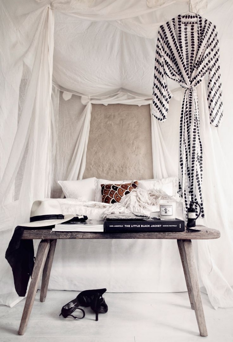 chambre-boheme-ciel-lit-blanc-coussins-décoratifs-table-bois-grisâtre