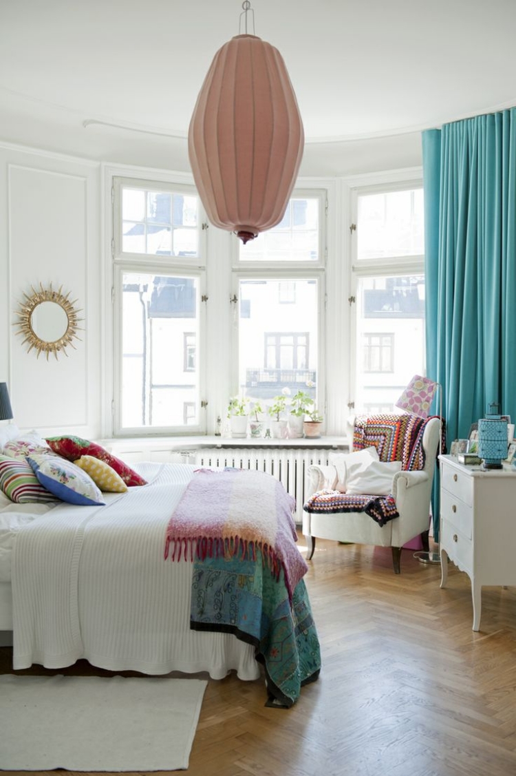 chambre-boheme-couvertures-coussins-motifs-multicolores-rideaux-turquoise-fauteuil-motifs-multicolores