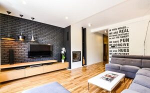 ecran-plat-mural-mur-brique-noire-parquet-canapé-gris
